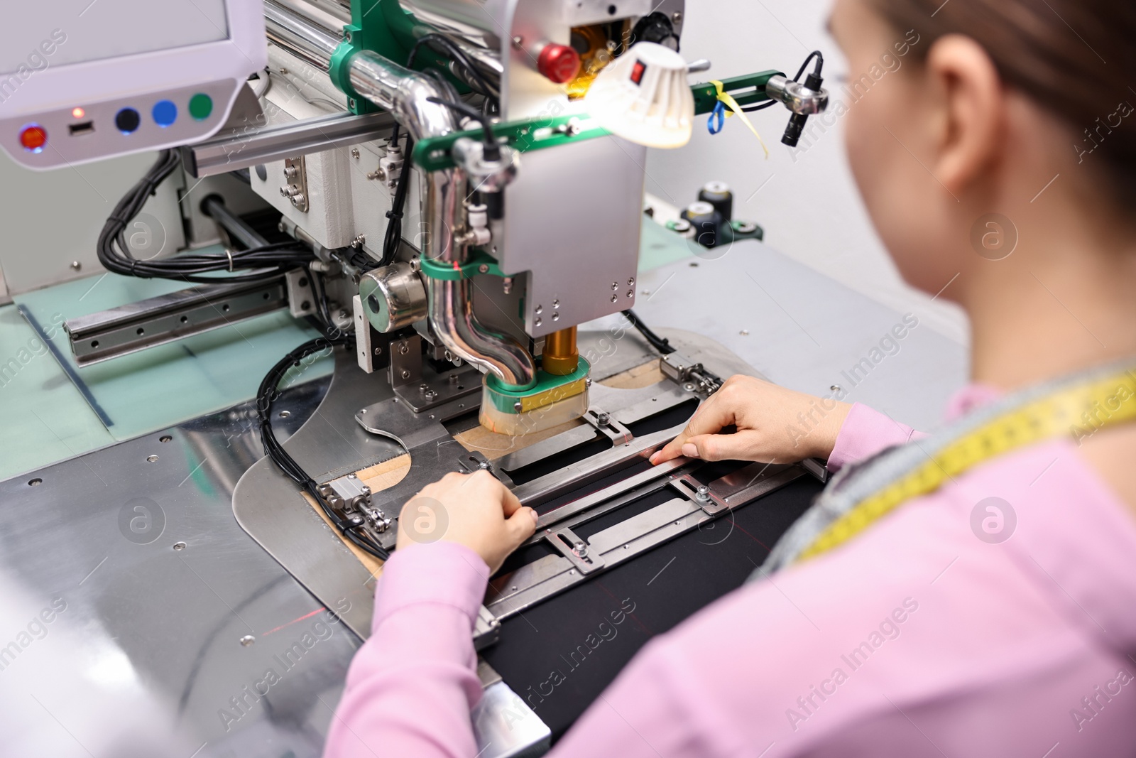 Photo of Young woman working with machine in professional workshop, closeup