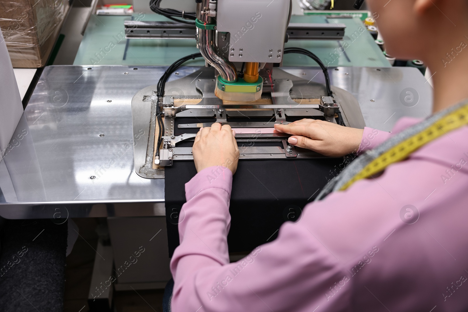 Photo of Young woman working with machine in professional workshop, closeup