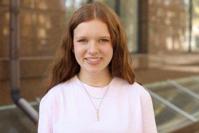 Photo of Portrait of happy teenage girl with long hair outdoors