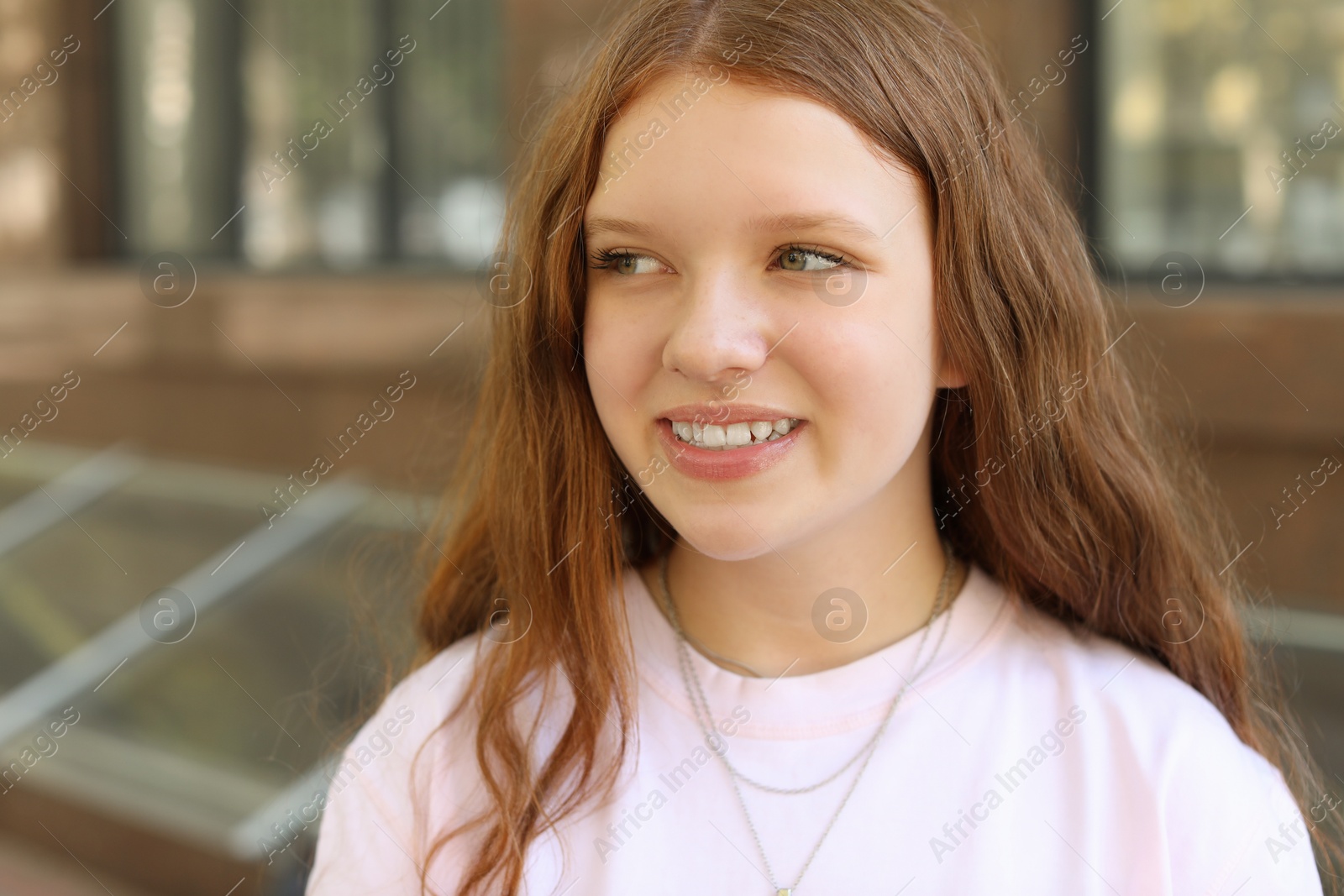 Photo of Portrait of happy teenage girl with long hair outdoors