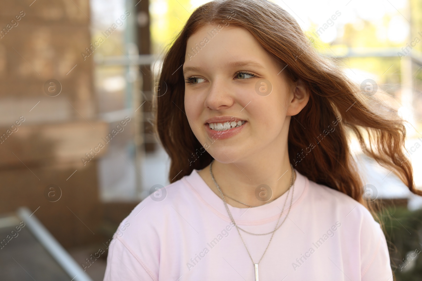 Photo of Portrait of happy teenage girl with long hair outdoors