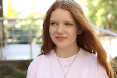 Photo of Portrait of happy teenage girl with long hair outdoors