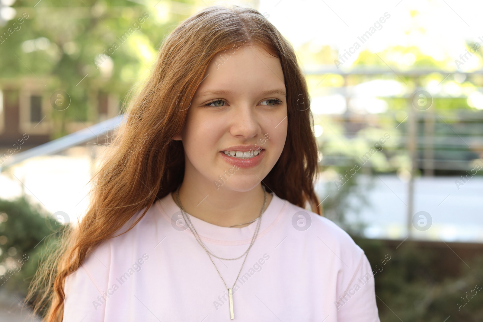 Photo of Portrait of happy teenage girl with long hair outdoors