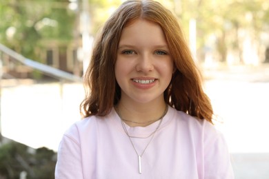 Photo of Portrait of happy teenage girl with long hair outdoors