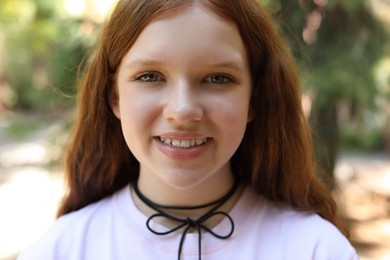 Portrait of happy teenage girl with long hair outdoors