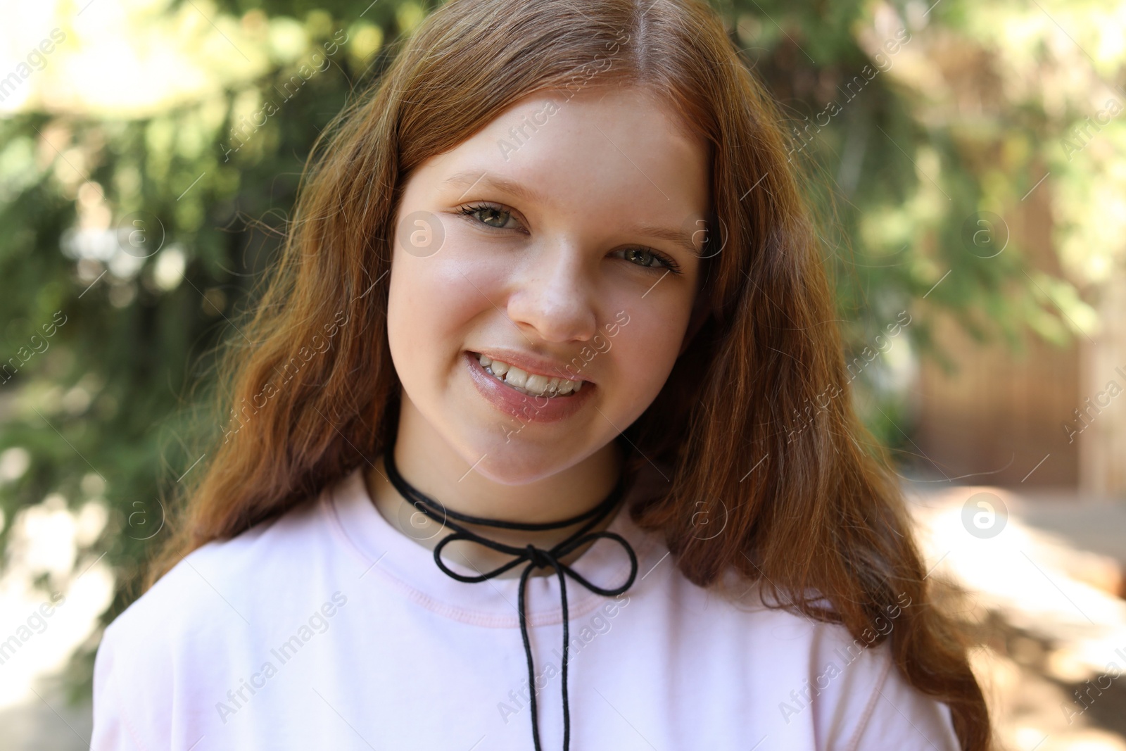 Photo of Portrait of happy teenage girl with long hair outdoors