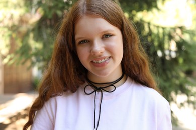 Photo of Portrait of happy teenage girl with long hair outdoors