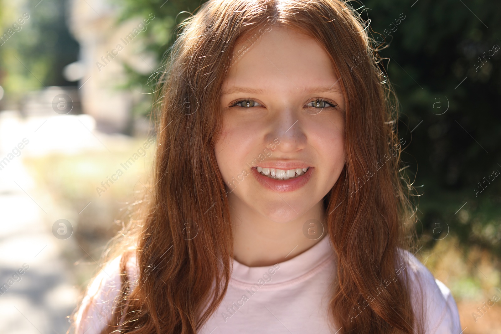 Photo of Portrait of happy teenage girl with long hair outdoors