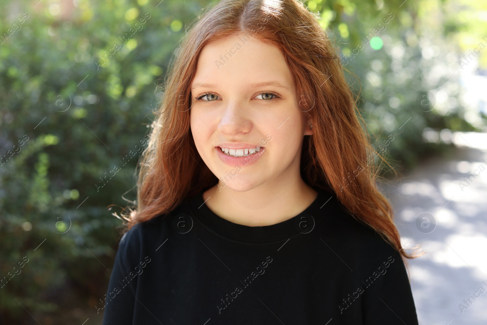 Photo of Portrait of happy teenage girl with long hair outdoors