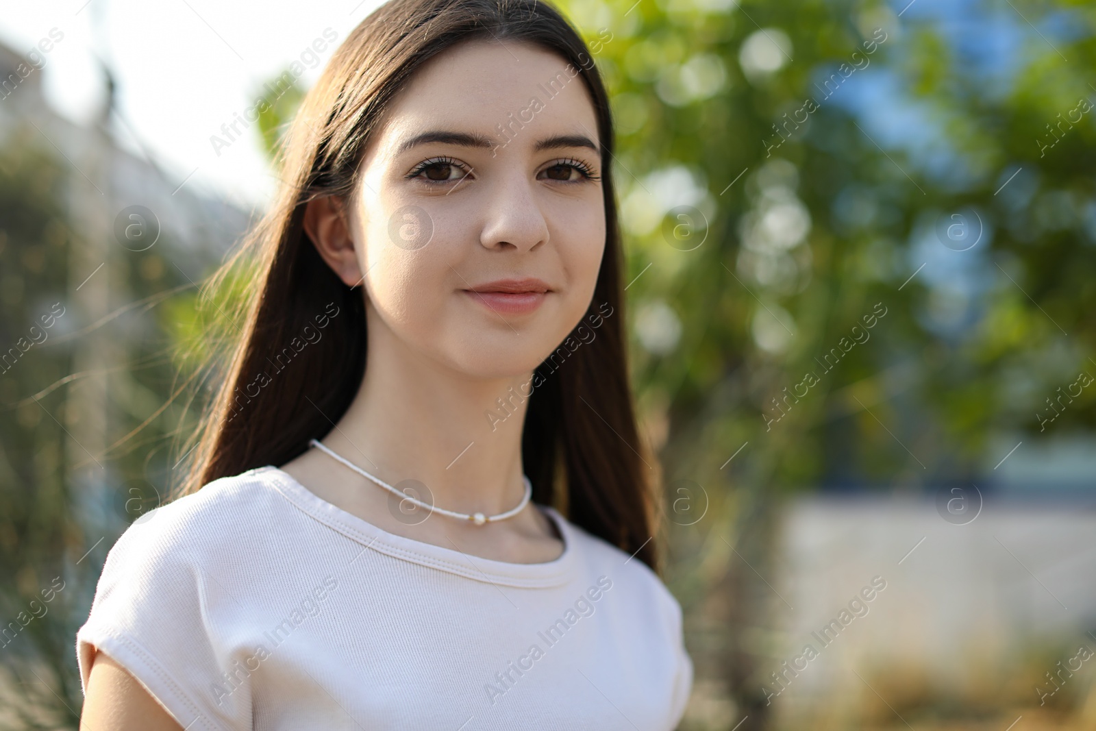 Photo of Portrait of beautiful teenage girl on city street. Space for text