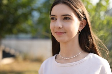 Photo of Portrait of beautiful teenage girl on city street. Space for text