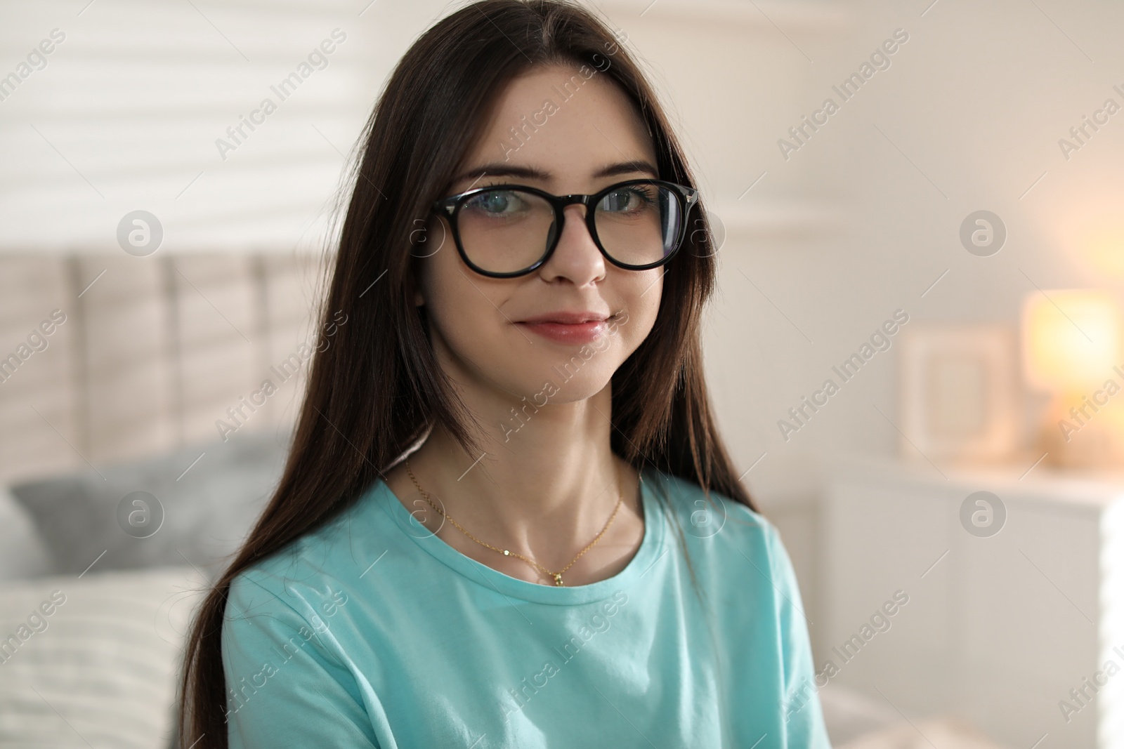 Photo of Portrait of beautiful teenage girl in glasses at home