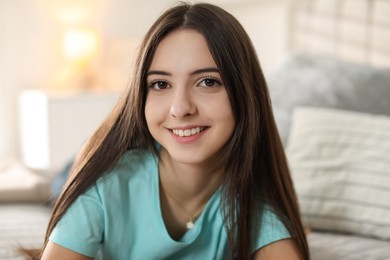 Photo of Portrait of smiling teenage girl on bed at home