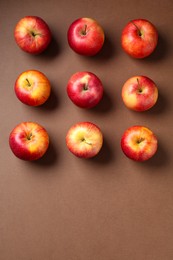 Photo of Ripe red apples on brown background, flat lay