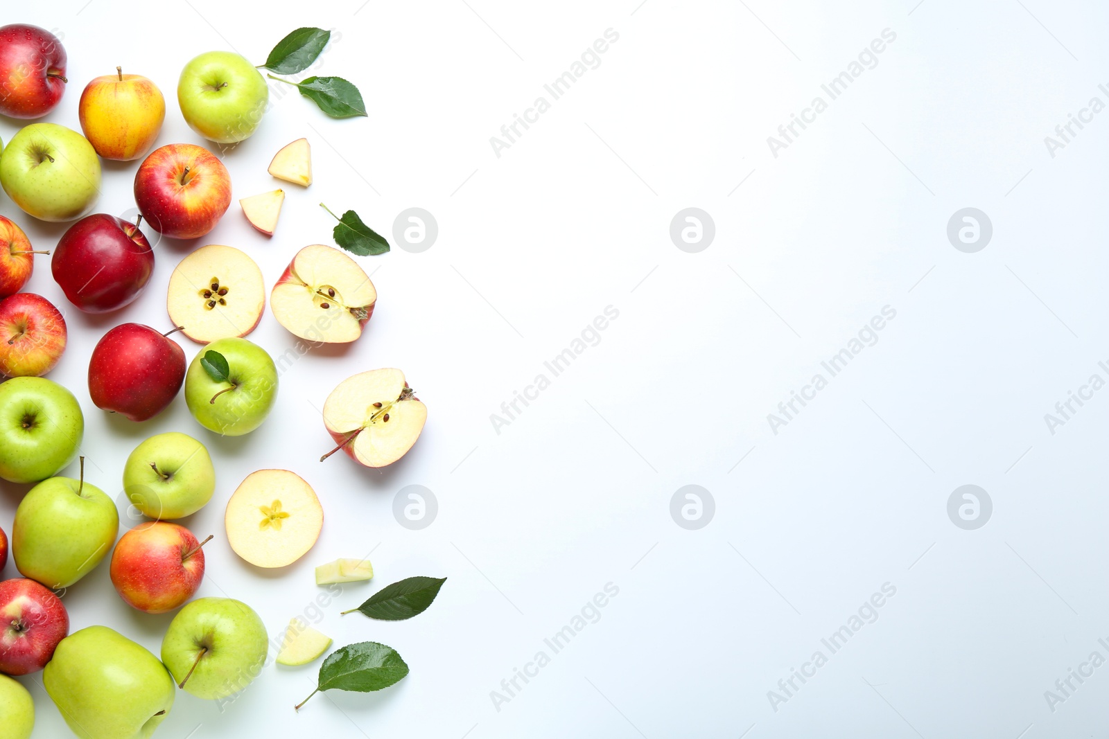 Photo of Flat lay composition with whole and cut apples on white background. Space for text