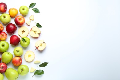 Flat lay composition with whole and cut apples on white background. Space for text