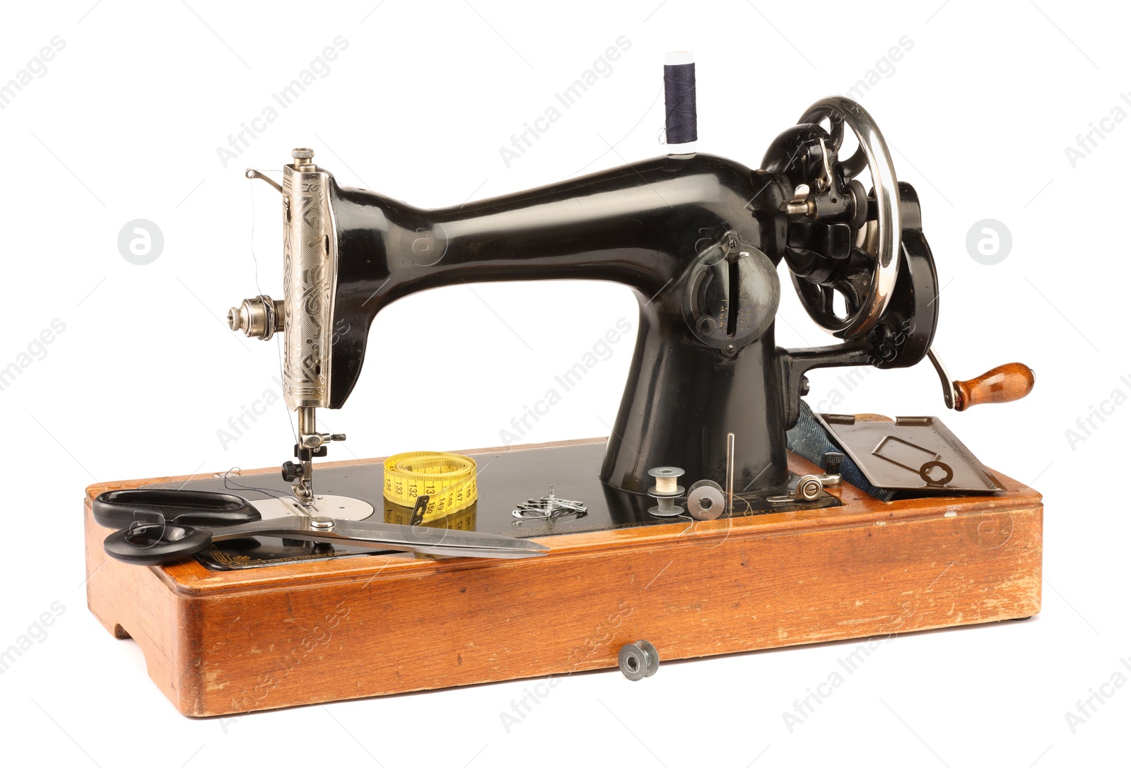 Photo of Sewing machine with measuring tape, scissors and spools of threads isolated on white