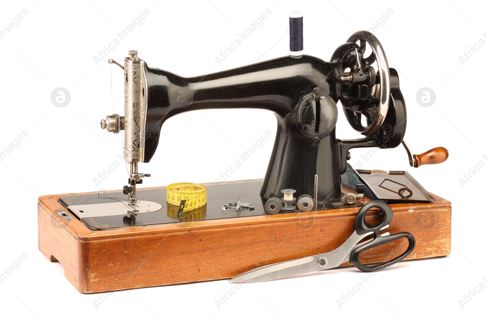 Photo of Sewing machine with measuring tape, scissors and spools of threads isolated on white