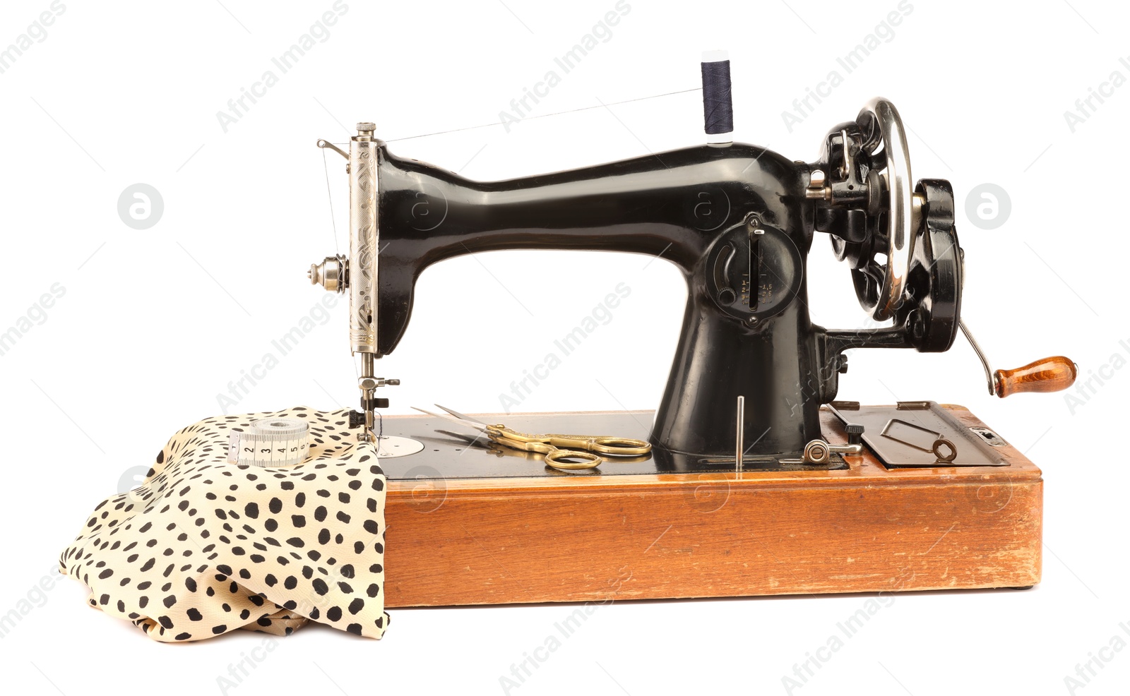 Photo of Sewing machine with fabric, measuring tape, scissors and spool of thread isolated on white