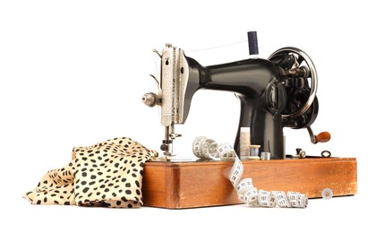 Photo of Sewing machine with fabric, measuring tape and spools of threads isolated on white