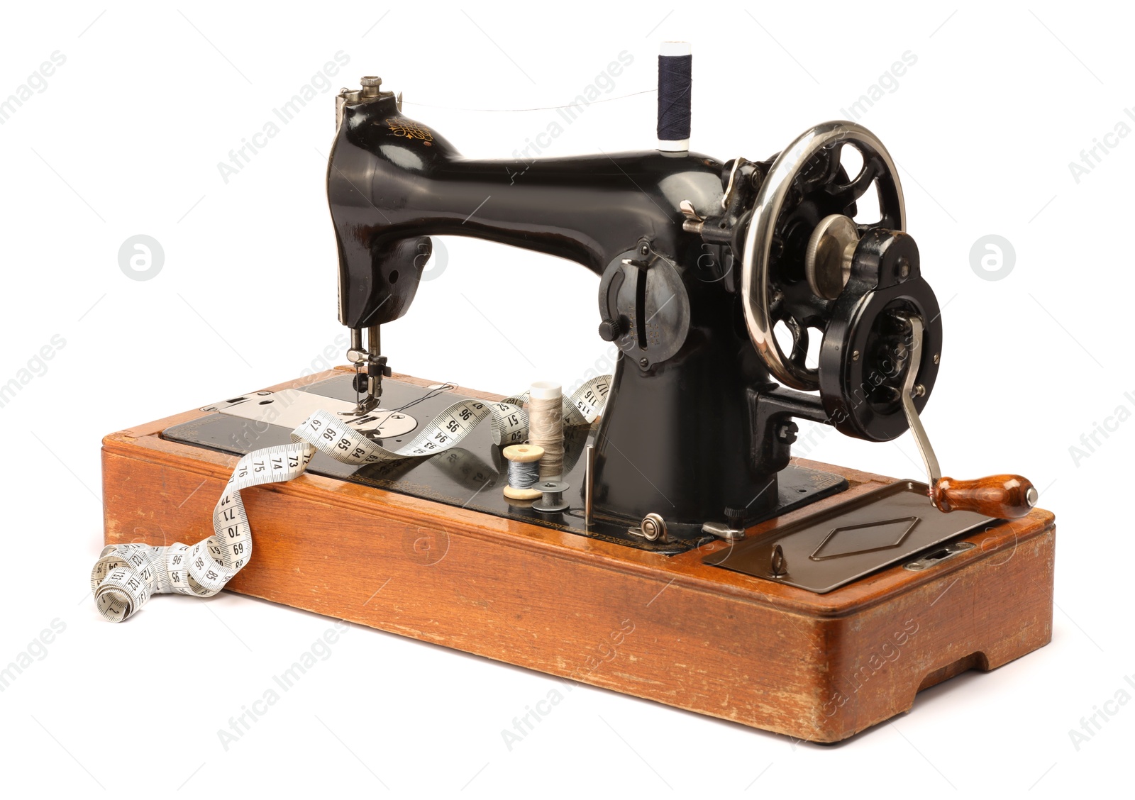 Photo of Sewing machine, measuring tape and spools of threads isolated on white