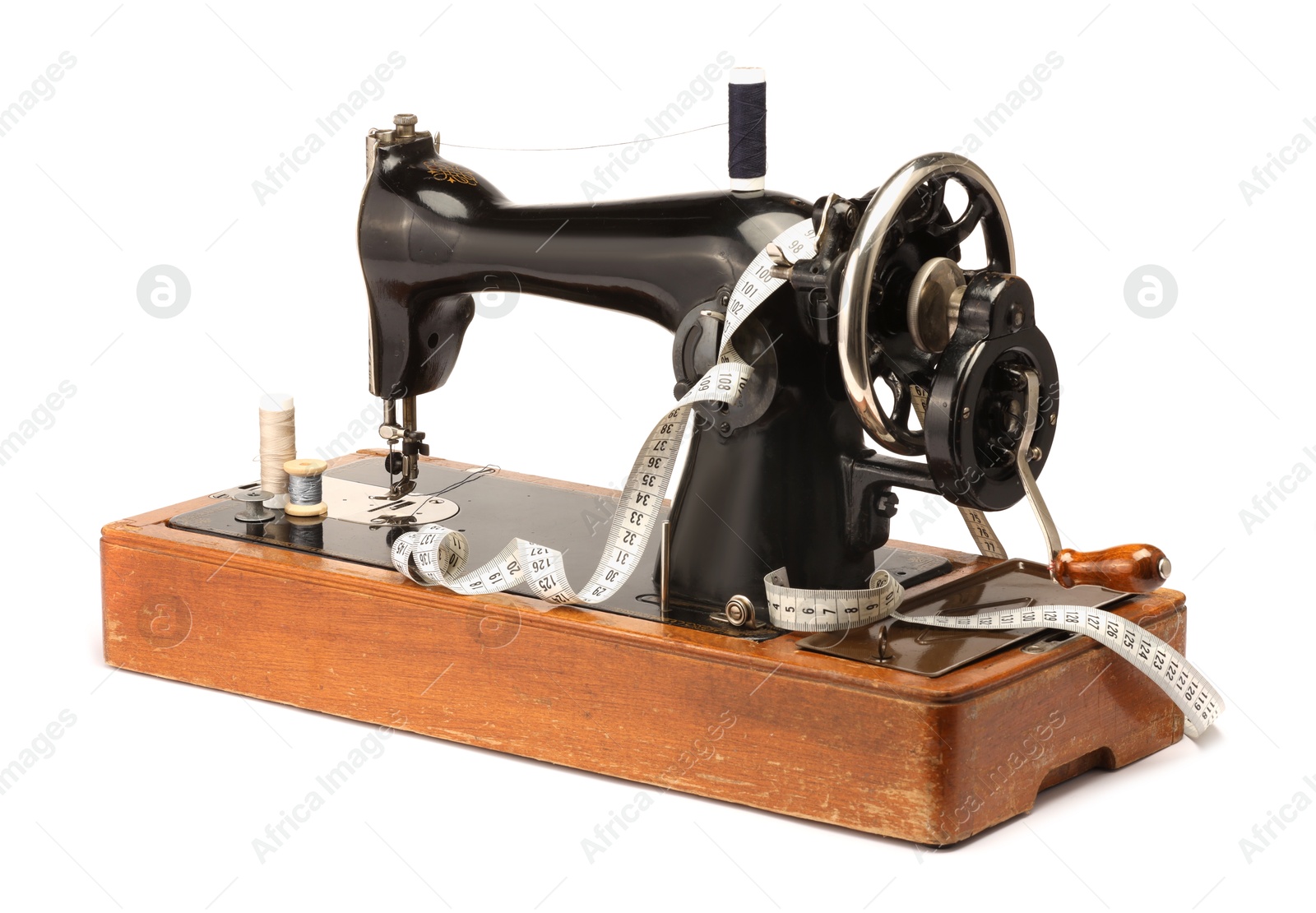 Photo of Sewing machine, measuring tape and spools of threads isolated on white