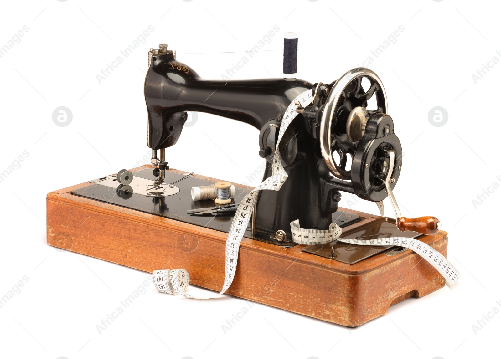 Photo of Sewing machine, measuring tape and spools of threads isolated on white