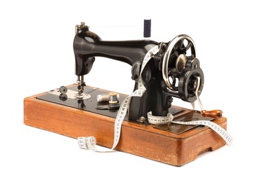 Photo of Sewing machine, measuring tape and spools of threads isolated on white