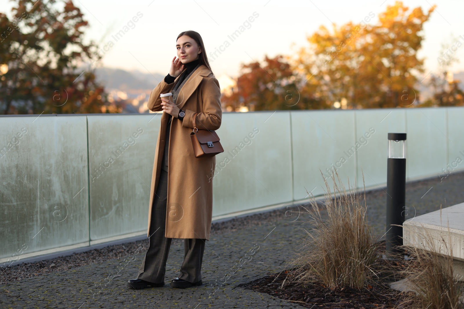 Photo of Businesswoman in stylish suit with paper cup outdoors