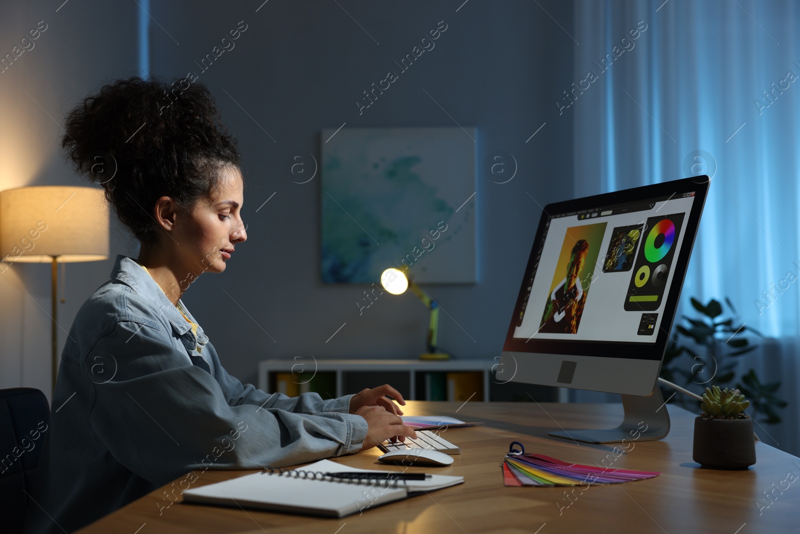 Photo of Designer working on computer indoors at night