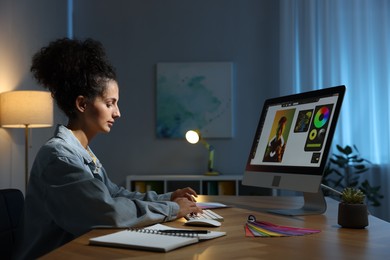 Designer working on computer indoors at night