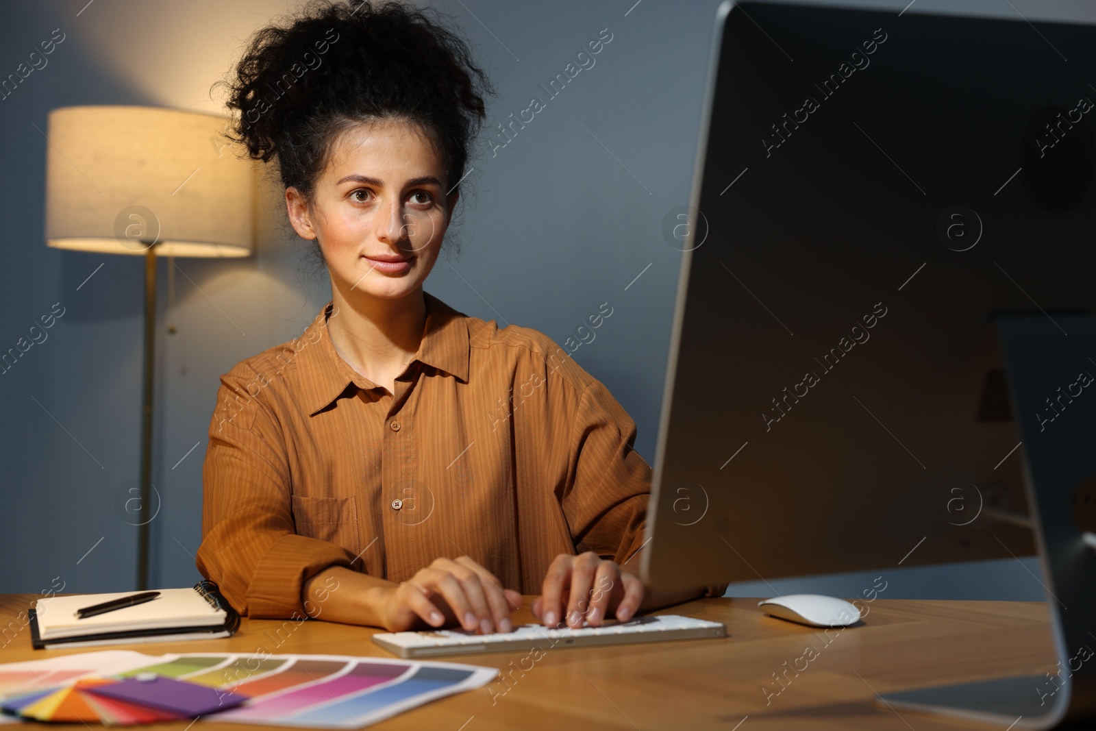 Photo of Designer working on computer indoors at night