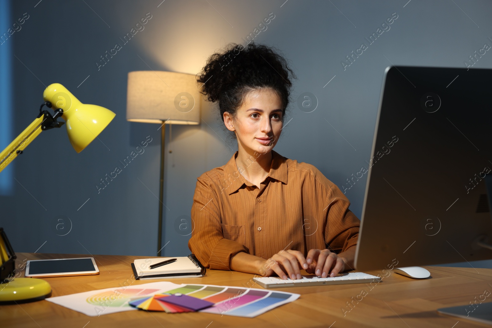 Photo of Designer working on computer indoors at night