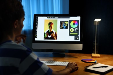 Designer working on computer indoors at night