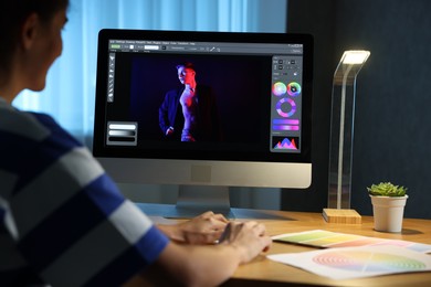 Designer working on computer indoors at night, closeup