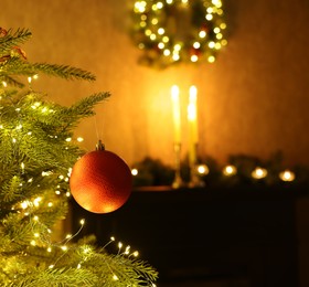 Christmas tree decorated with bauble and festive lights indoors, closeup. Space for text