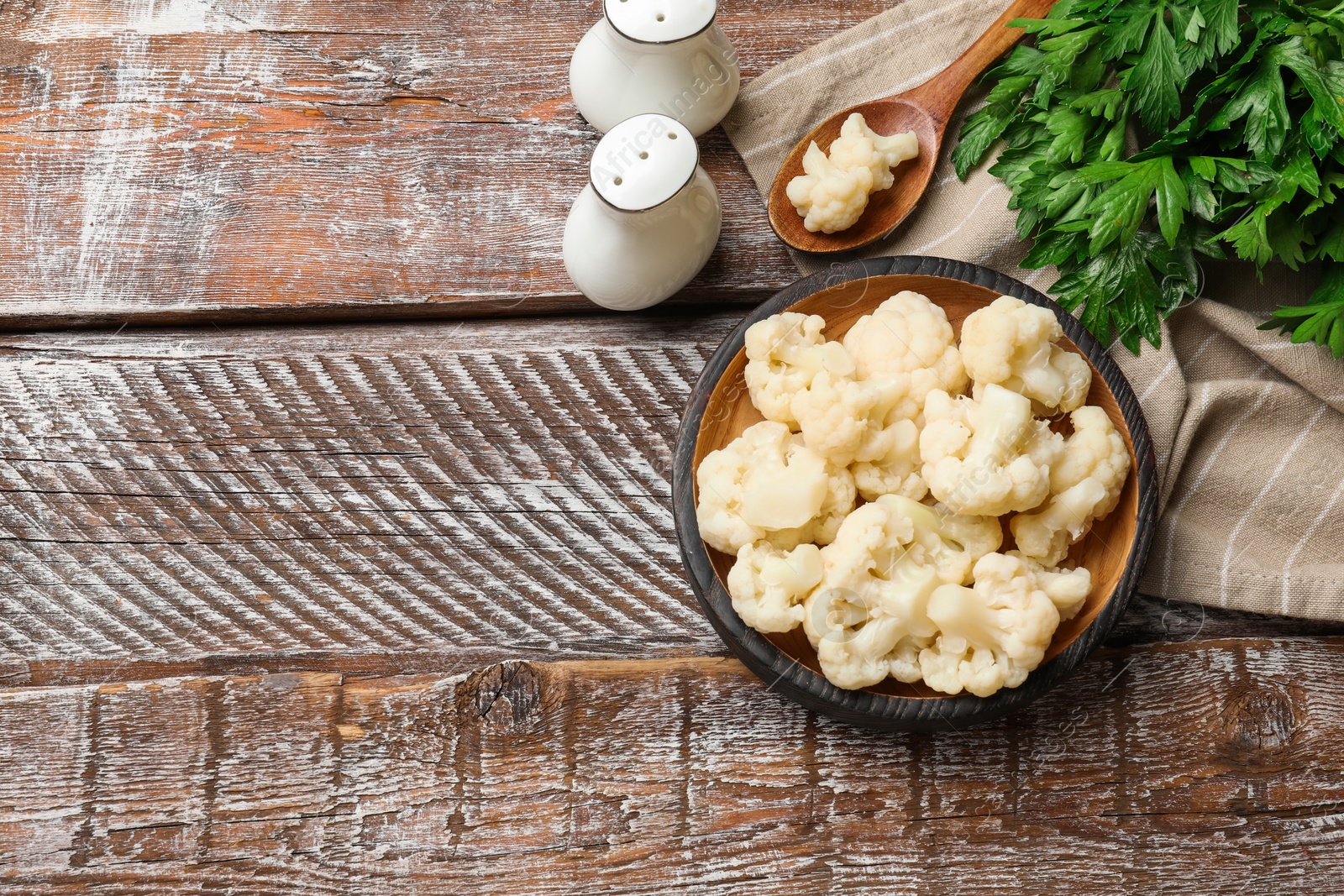 Photo of Tasty cauliflower served on wooden table, flat lay. Space for text