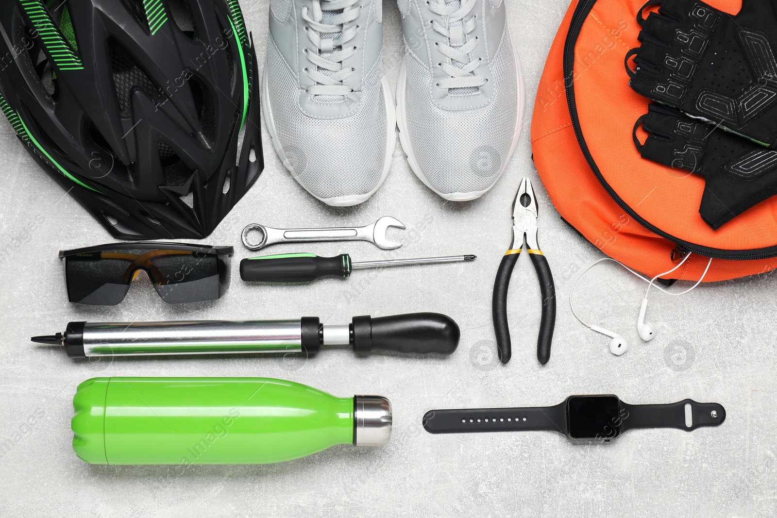 Photo of Bicycle accessories and tools on grey textured background, flat lay