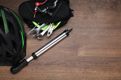 Photo of Bicycle helmet and tools on wooden background, flat lay. Space for text