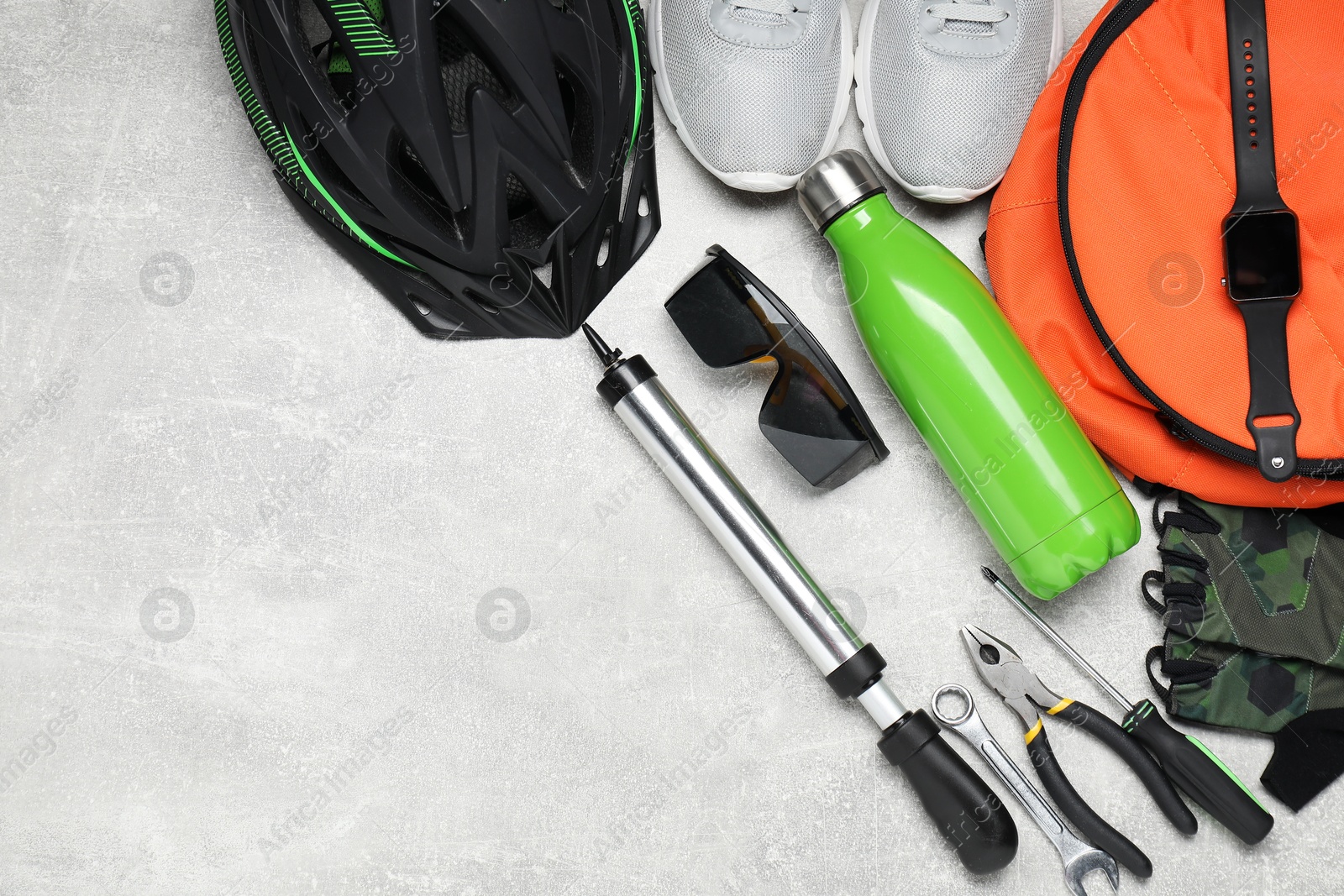 Photo of Bicycle accessories and tools on grey textured background, flat lay. Space for text