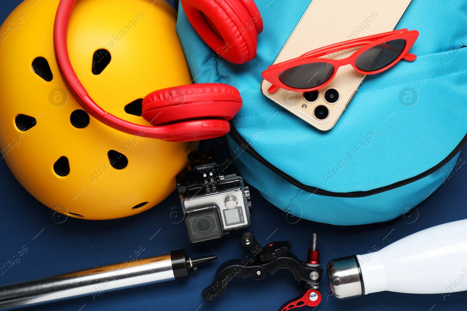 Photo of Bicycle helmet, accessories and equipment on blue wooden background, above view