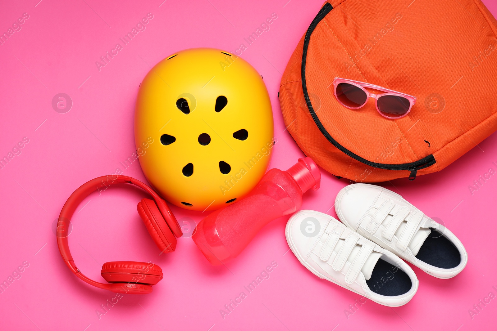 Photo of Bicycle helmet, accessories and sneakers on pink background, flat lay