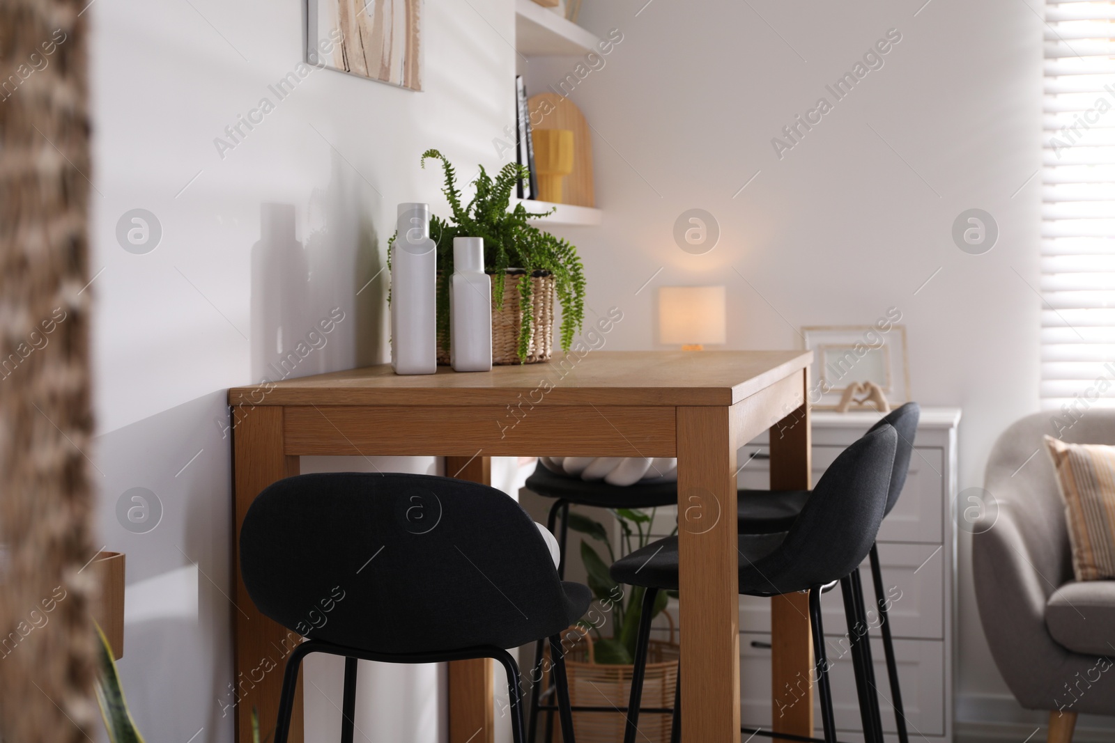 Photo of Bar stools near table in room. Interior design