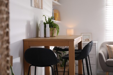 Photo of Bar stools near table in room. Interior design