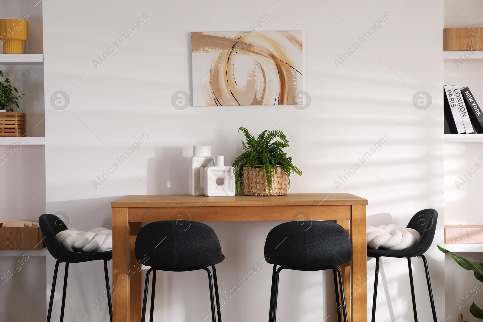 Photo of Bar stools near table in room. Interior design