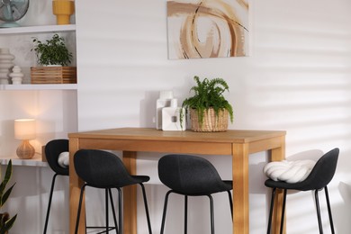 Photo of Bar stools near table in room. Interior design