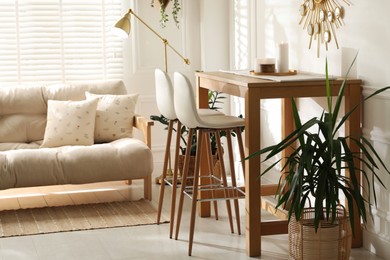 Bar stools near wooden table in room