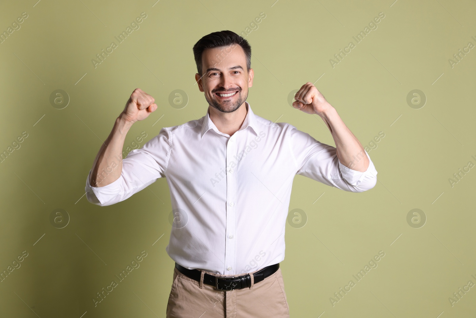 Photo of Portrait of happy winner on pale olive background