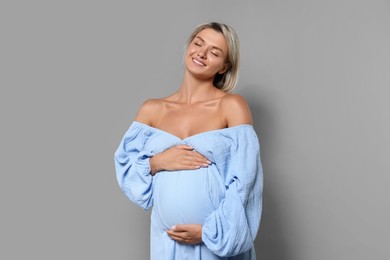 Photo of Portrait of beautiful pregnant woman on grey background