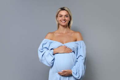 Photo of Portrait of beautiful pregnant woman on grey background